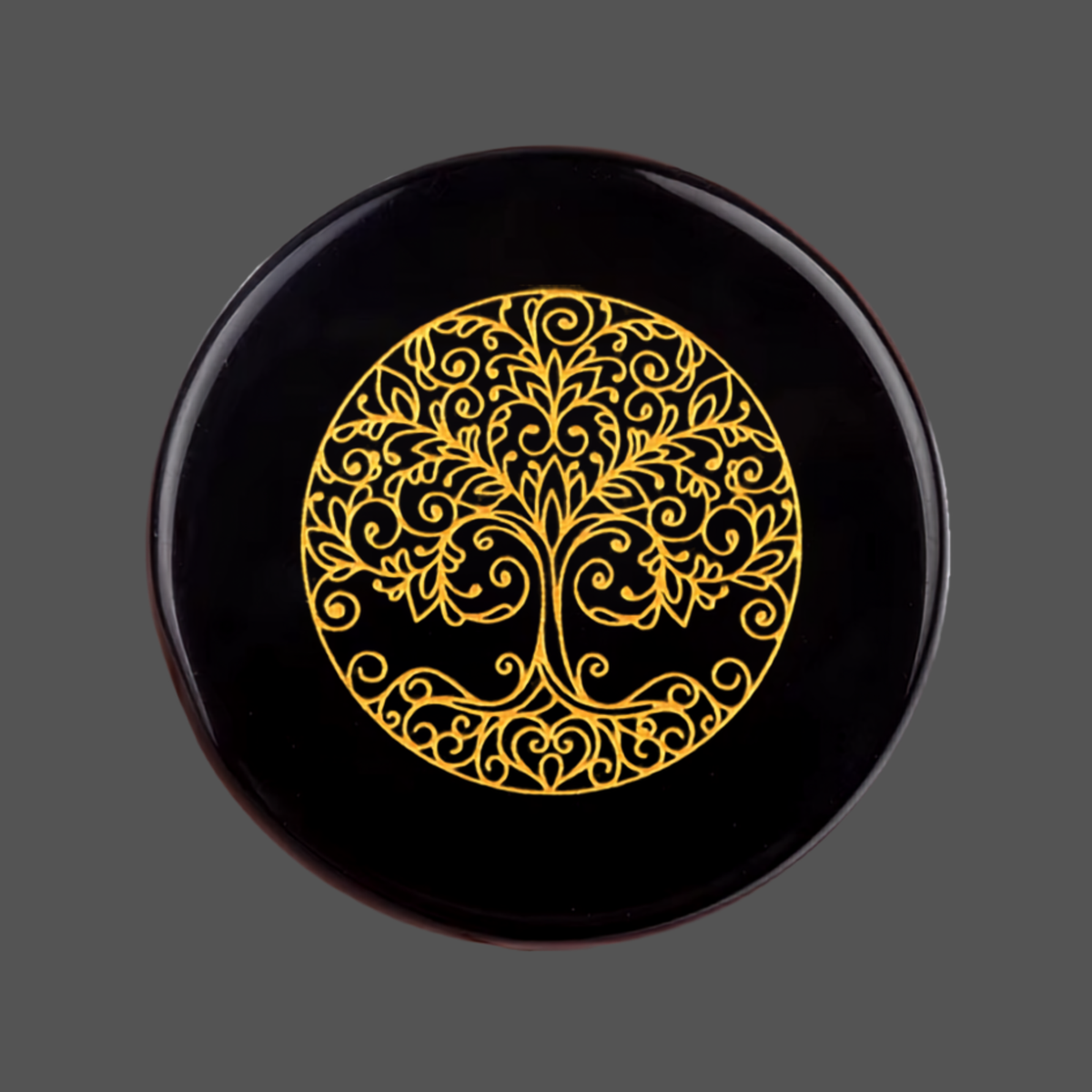 Black obsidian stone with carved image of a tree for meditation or spiritual practice 