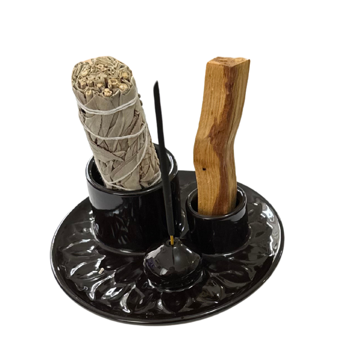 Sage bundle and Palo Santo incense sticks in a black ceramic holder.
