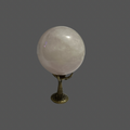 Clear quartz Crystal ball on a claw shape stand against a gray background