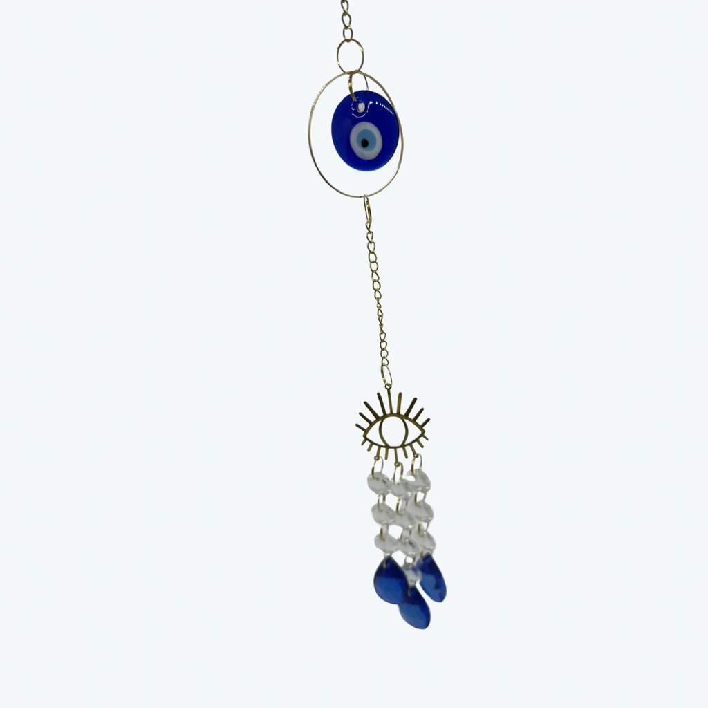 Decorative hanging charm with blue evil eye, sun design, and blue beads on a white background