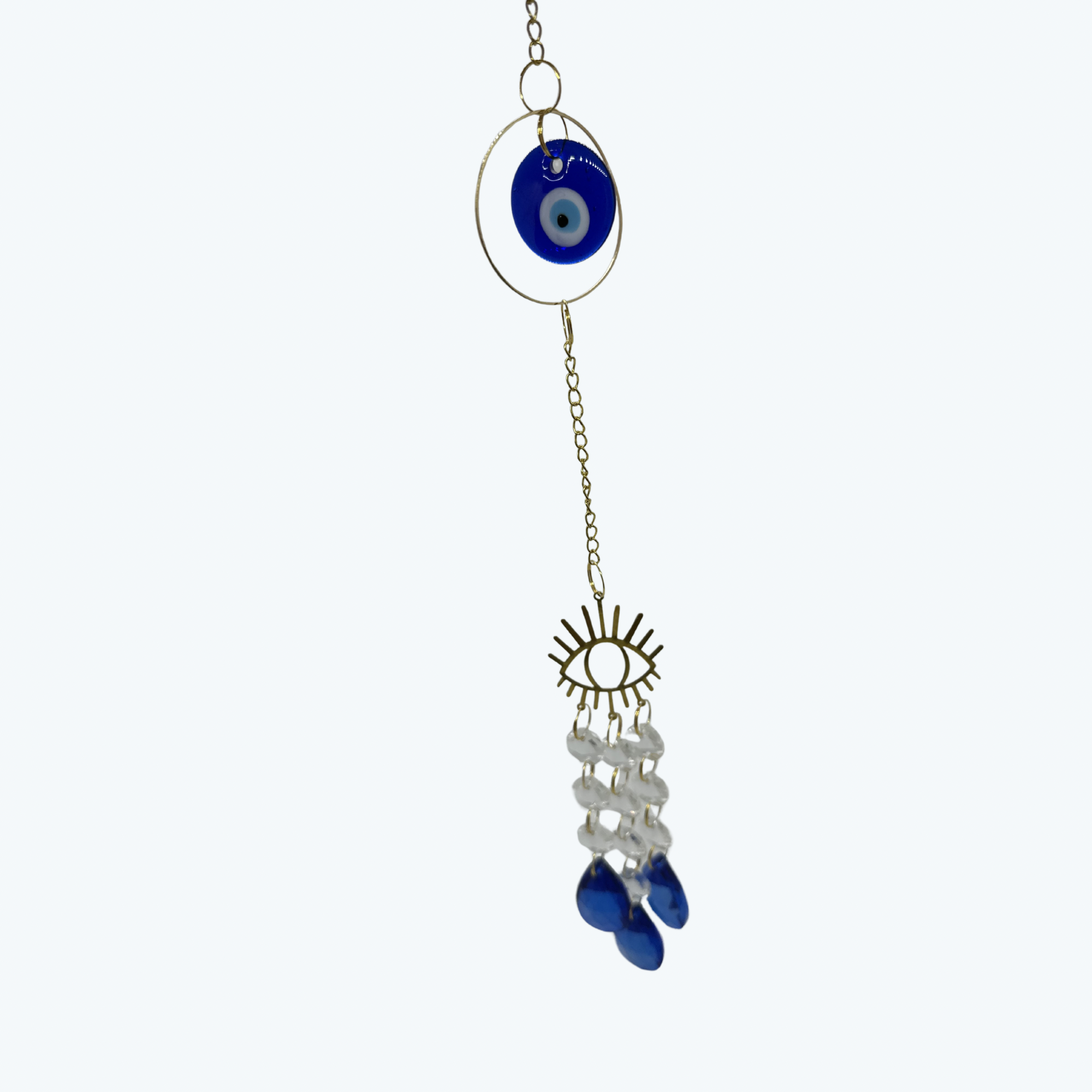 Decorative hanging charm with blue evil eye, sun design, and blue beads on a white background