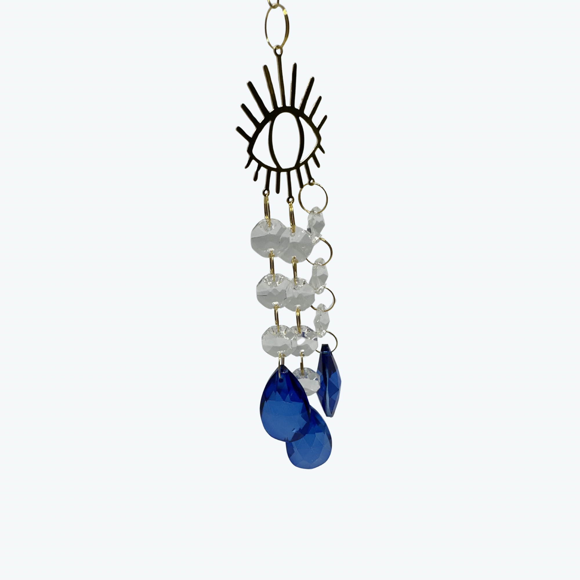 Evil eye metal shape with 3 lines of crystals hanging off the bottom