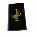 Green aventurine frog pendant on a silver chain in a black display box.