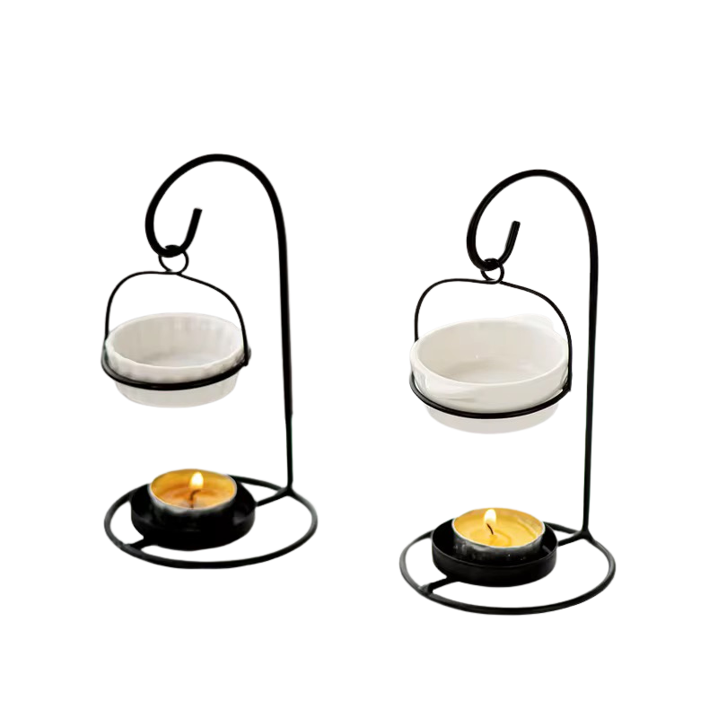 Two black metal candle holders with curved hooks, each holding a white bowl and a tealight candle, shown on a plain white background.