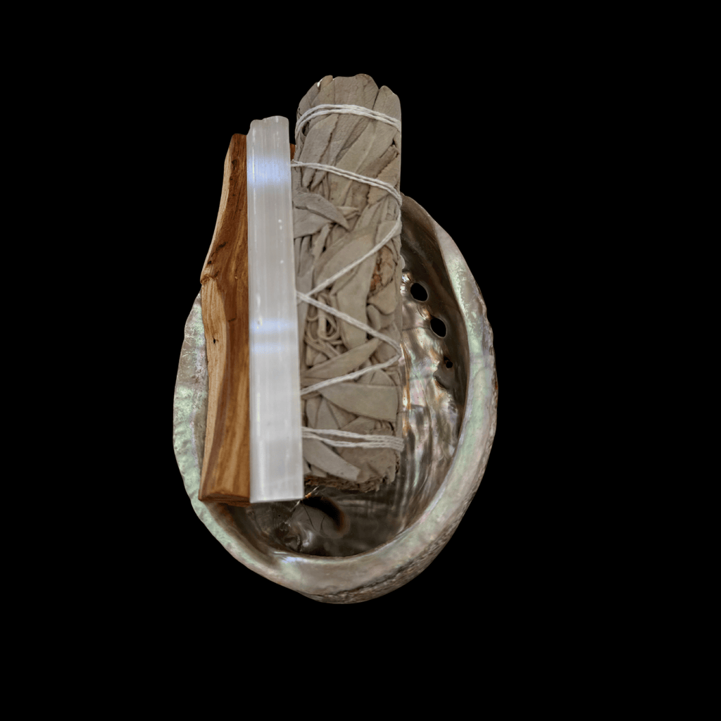 Sage smudge kit bundle tied with string in a metal bowl, with a selenite wand and wooden stick.