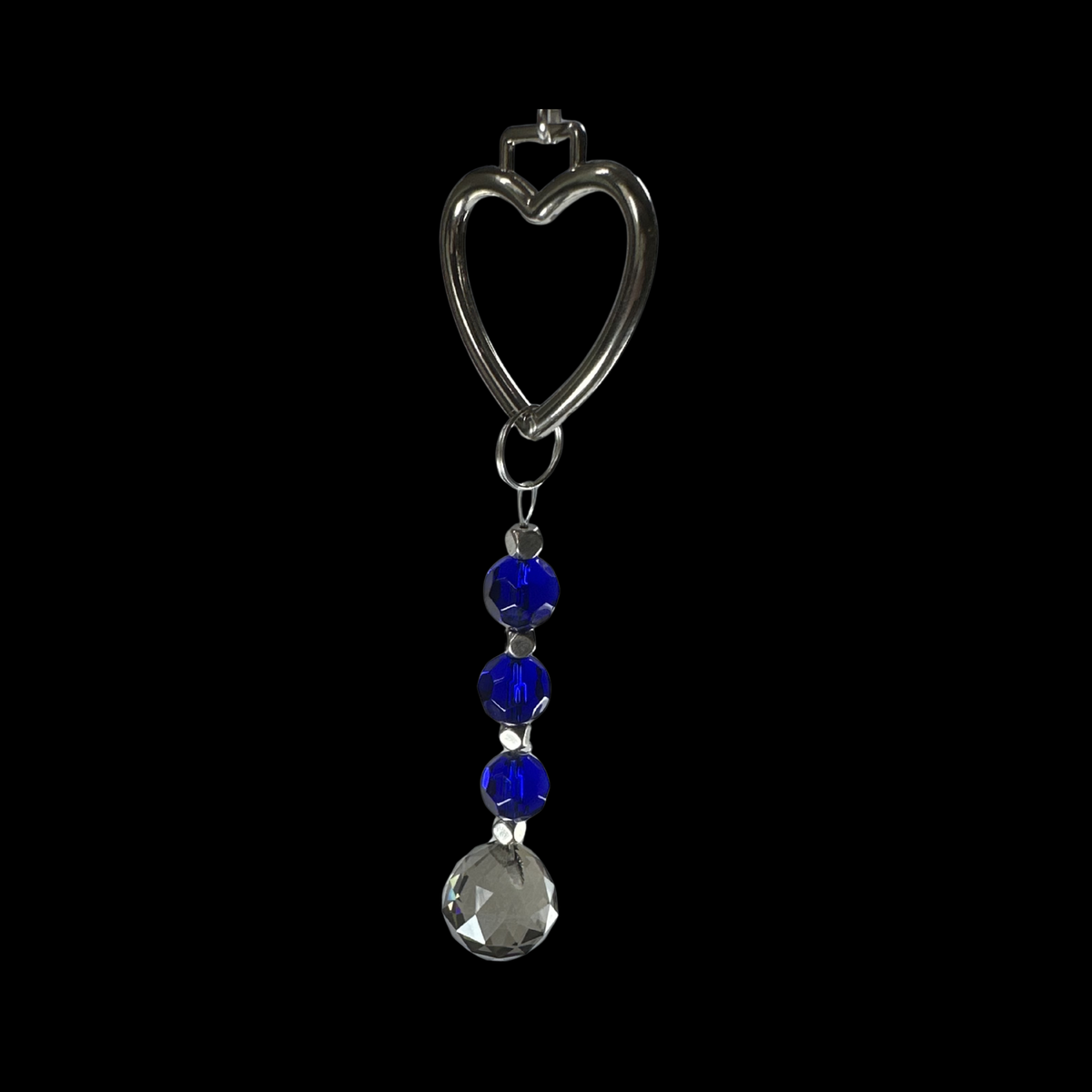 Skull shaped clear crystal hanging with blue and clear beads on a black background